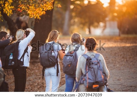 Group of photographer taking pictures of family on photography shooting workshop, outdoor Royalty-Free Stock Photo #2073947039