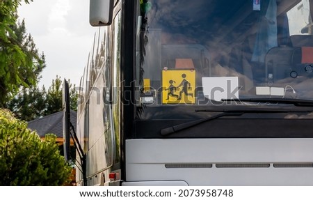 Single empty modern school trip bus, kids transport designated coach vehicle detail, closeup, nobody, frontal shot. Children journey safety concept. Traffic, transportation, means of transport