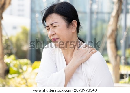 old senior woman suffers from shoulder joint pain, shoulder stiffness or osteoporosis Royalty-Free Stock Photo #2073973340