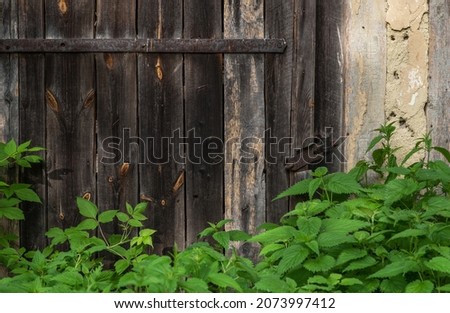 Part old weathered wooden barn door with steel hinges. Distressed wood barn door panels.