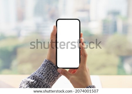 close up hand holding mock-up phone blank screen and cityscape blur background