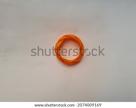 Tie an orange broom stick made of plastic on a white background