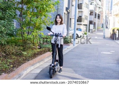 Person using an Electric Scooter Royalty-Free Stock Photo #2074010867