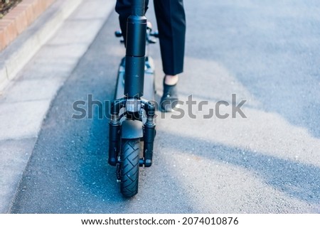 Person using an Electric Scooter Royalty-Free Stock Photo #2074010876