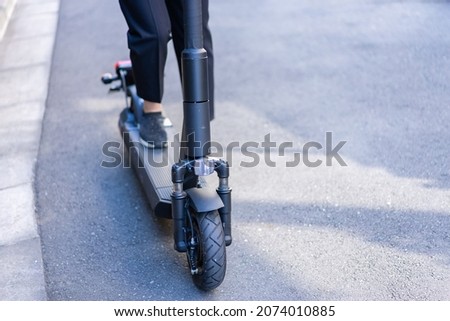 Person using an Electric Scooter Royalty-Free Stock Photo #2074010885
