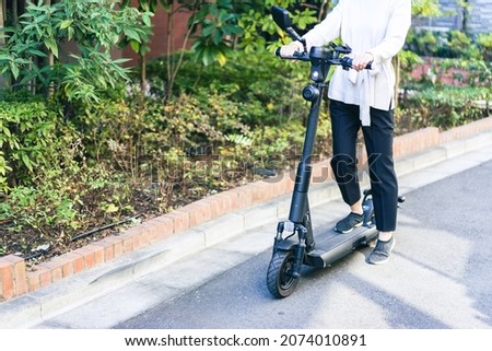 Person using an Electric Scooter Royalty-Free Stock Photo #2074010891