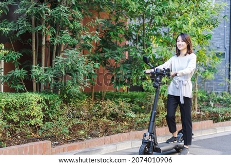 Person using an Electric Scooter Royalty-Free Stock Photo #2074010906