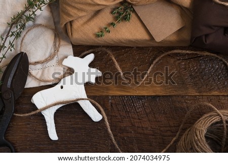 Eco friendly, cloth wrapped gift with jute twine, recycled paper tag, and a homemade moose ornament. Antique scissors. 