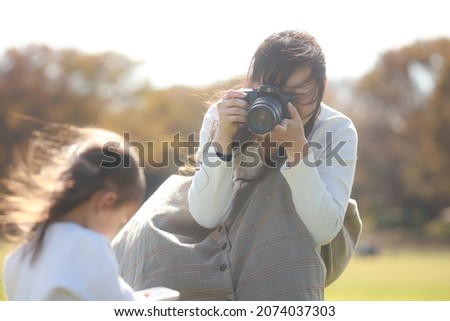 Mother taking pictures of children 
 Royalty-Free Stock Photo #2074037303