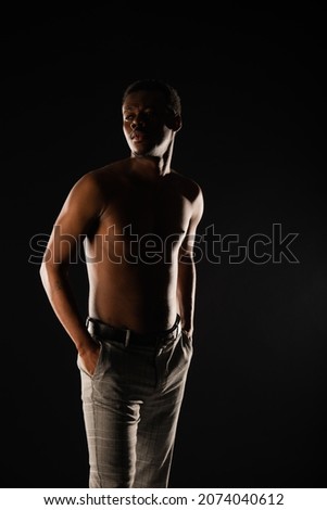 Silhouette of young black male posing on dark background