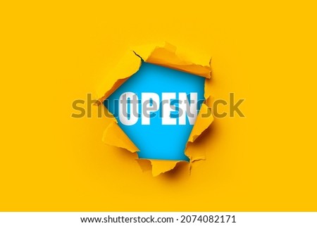 Bright yellow torn paper inside a hole with the inscription Open on a blue background