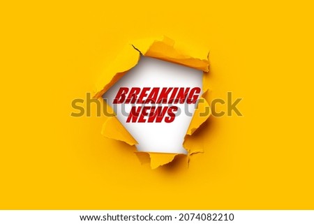 Bright yellow torn paper inside in a hole Breaking news on a white background  Royalty-Free Stock Photo #2074082210
