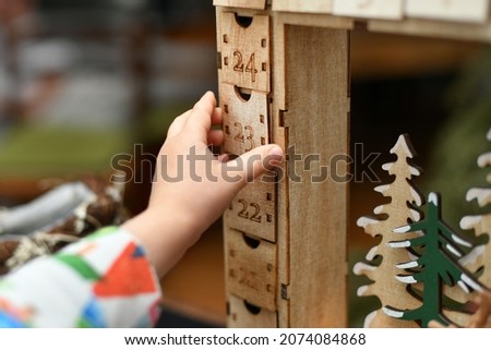 Hand opens wooden advent calendar