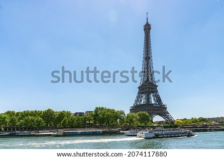 small paris street with view on the famous paris eiffel tower on a cloudy rainy day with some sunshine Royalty-Free Stock Photo #2074117880