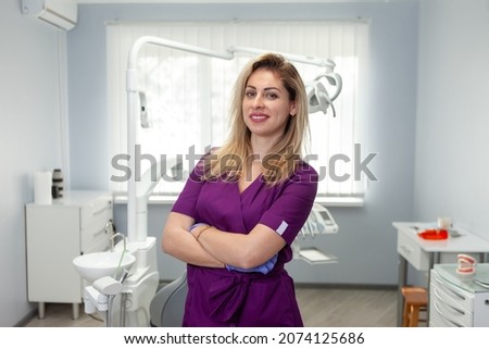 Portrait of confident, smiling female dentist at the dental office Royalty-Free Stock Photo #2074125686