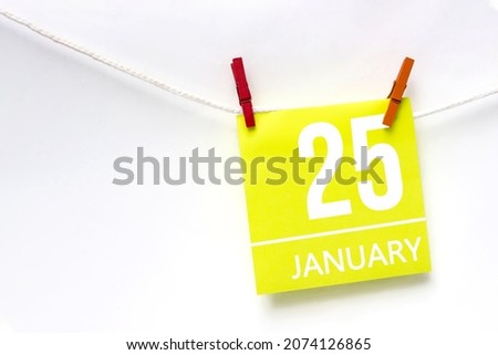 January 25th. Day 25 of month, Calendar date. Paper cards with calendar day hanging rope with clothespins on white background. Winter month, day of the year concept