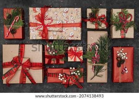Winter xmas holiday theme. Merry Christmas and Happy Holidays greeting card, banner. Horizontal dark background top view. Concept of greetings. Many gifts. Noel. Happy New Year. Flat lay. Red ribbon. Royalty-Free Stock Photo #2074138493