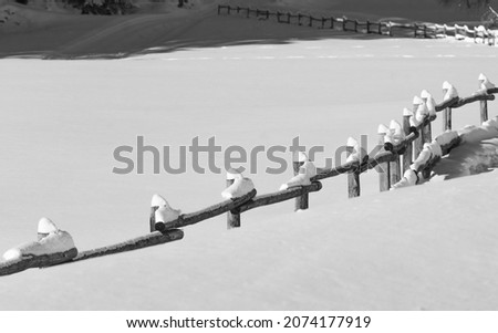wooden fence topped with snow