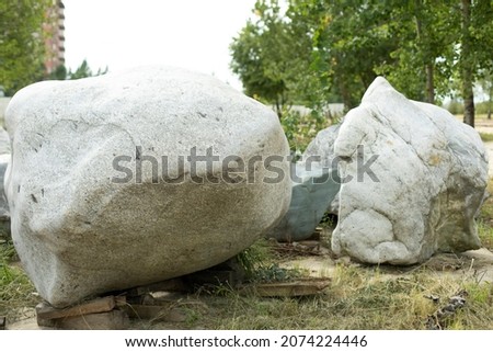 Two large gray boulders close-up in the city park. The texture of the stone, the decorative design of parks in Russia. Outdoor shooting. Walks around the city.