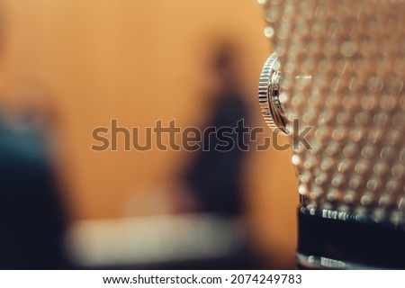 image for graphic resources with selective focus on professional condenser microphone knob with blurred background, with copy space on the left, music and entertainment advertising concept.