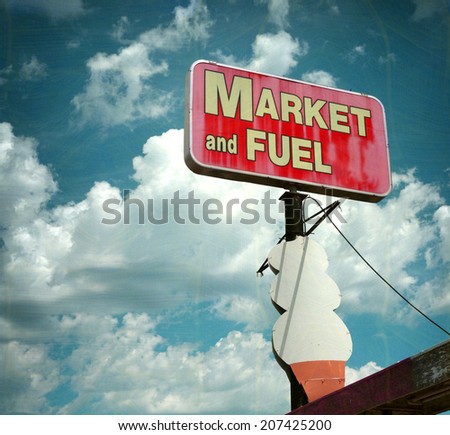  aged and worn vintage photo of  market and fuel sign with giant ice cream cone                            