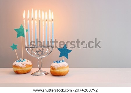 Religion image of jewish holiday Hanukkah background with menorah (traditional candelabra), doughnut and candles