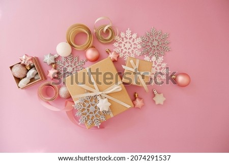Christmas background with gift box in pink colors. Xmas celebration, greetings, preparation for winter holidays. Festive mockup, top view, flat lay with copy space.