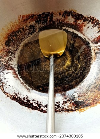 picture of a dirty and dull frying pan with oil that is ready to be used to fry Asian specialties