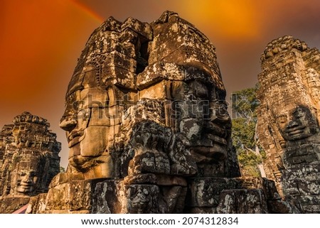 Colorful sunset at Ancient stone faces of Bayon temple, Angkor, Cambodia