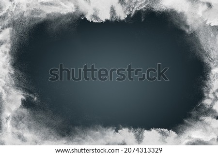 Abstract white powder snow cloud border on dark background. Design of picture frame