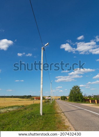 asphalt road in the countryside and a blue sky with white clouds