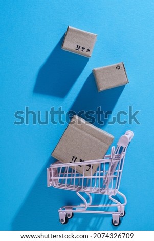Online shopping and shipping concept, Shopping cart and post boxes on blue background,