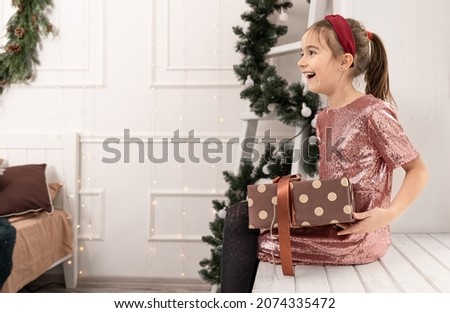 Funny little girl with a Christmas gift box.