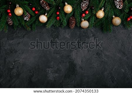 Christmas background with green fir branches, cones and golden and red decor. Top view with copy space