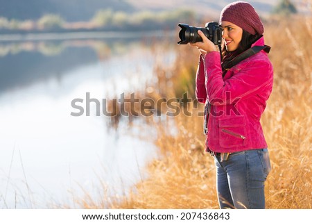 beautiful photographer take photo outdoors by the lake in autumn
