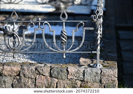 low gray metal fence on a stone masonry foundation