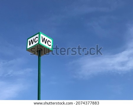 WC logo, sign of public toilets on the street on sky background. Selective focus.