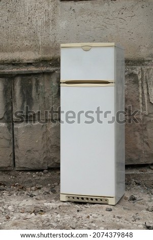 An old refrigerator was thrown away on the street. Close-up. Royalty-Free Stock Photo #2074379848