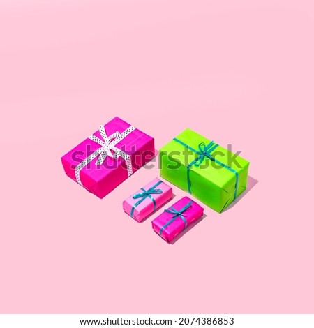 Christmas and party gifts in pink and green colors. Minimal holiday composition on a pink background.