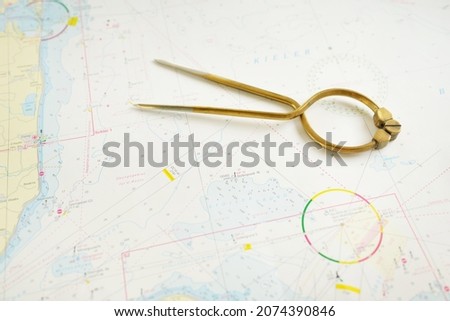 Antique W HC 6" brass dividers calipers nautical navigation chart tool and white map close-up. Vintage still life. Sailing, travel accessories. Planning, concept art, graphic resources, copy space Royalty-Free Stock Photo #2074390846