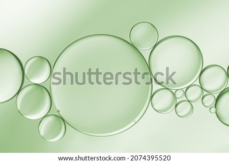 Oil droplets created an art image on pale green light effects background.