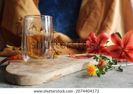 Glass cup tea autumn leaves orange blue wood yeloow flowers 