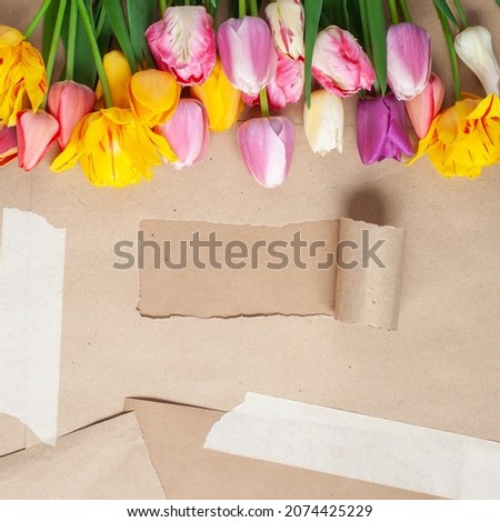 Tulips on kraft paper with a hole and inscription. Happy Mother's day. Top view
