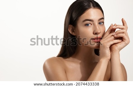 Skin care and spa. Young woman with healthy hair and glowing body skin, touching her face without makeup, concept of skincare cleansing products, white background Royalty-Free Stock Photo #2074433338
