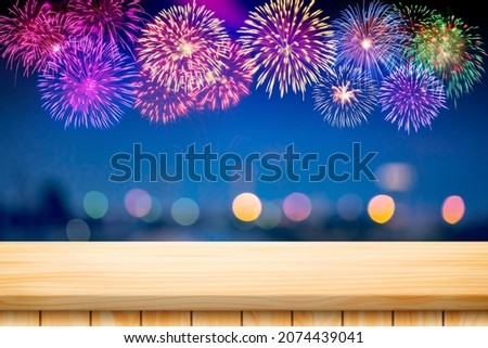 Wood table floor and Amazing Beautiful firework on blurred bokeh background for celebration anniversary merry christmas eve and happy new year.