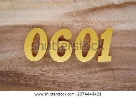 Golden Arabic numerals 0601 on a dark brown to white wood grain background.