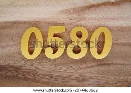 Golden Arabic numerals 0580 on a dark brown to white wood grain background.
