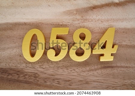 Golden Arabic numerals 0584 on a dark brown to white wood grain background.