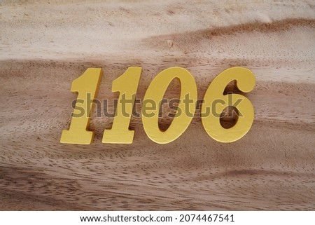 Golden Arabic numerals 1106 on a dark brown to white wood grain background.