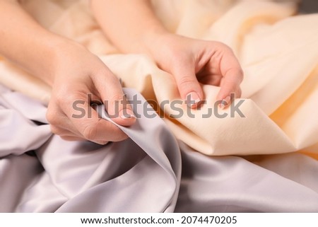 Woman touching different soft fabrics, closeup view Royalty-Free Stock Photo #2074470205
